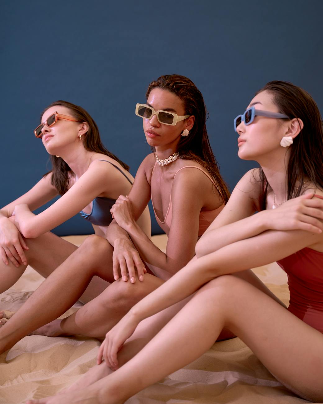 women in bikini and swimsuits on sand